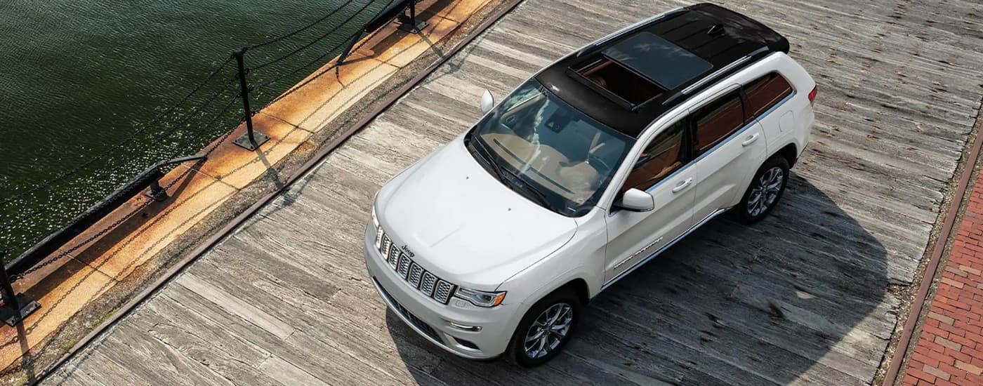 A white 2021 Jeep Grand Cherokee is shown from above parked on a dock.