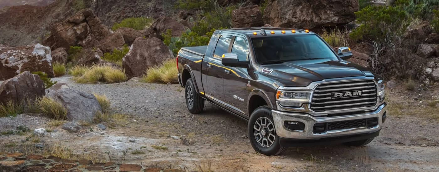 A grey 2021 Ram 1500 Limited Longhorn is shown parked on a remote trail.