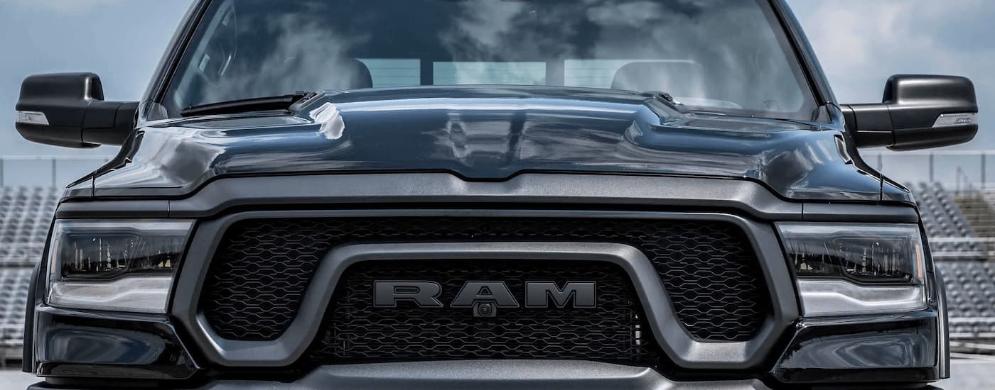 A close up of the front of a black 2023 Ram 1500 shows the grille and headlights.