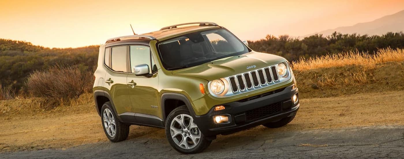 A green 2015 Jeep Renegade is shown parked on the side of the road after viewing used Jeeps for sale.