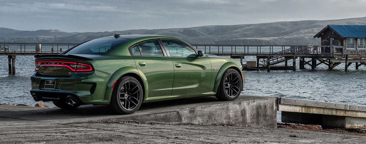 A green 2022 Dodge Charger Scat Pack is shown from the side parked at a pier.