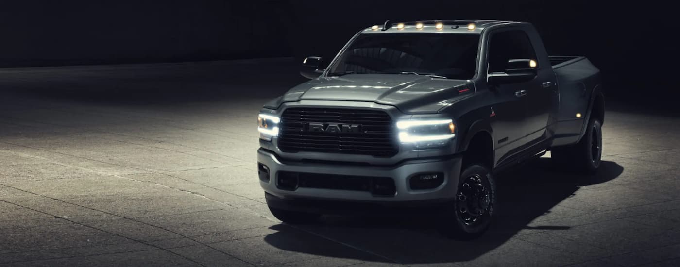A silver 2022 Ram 3500 is shown parked in a dark warehouse.